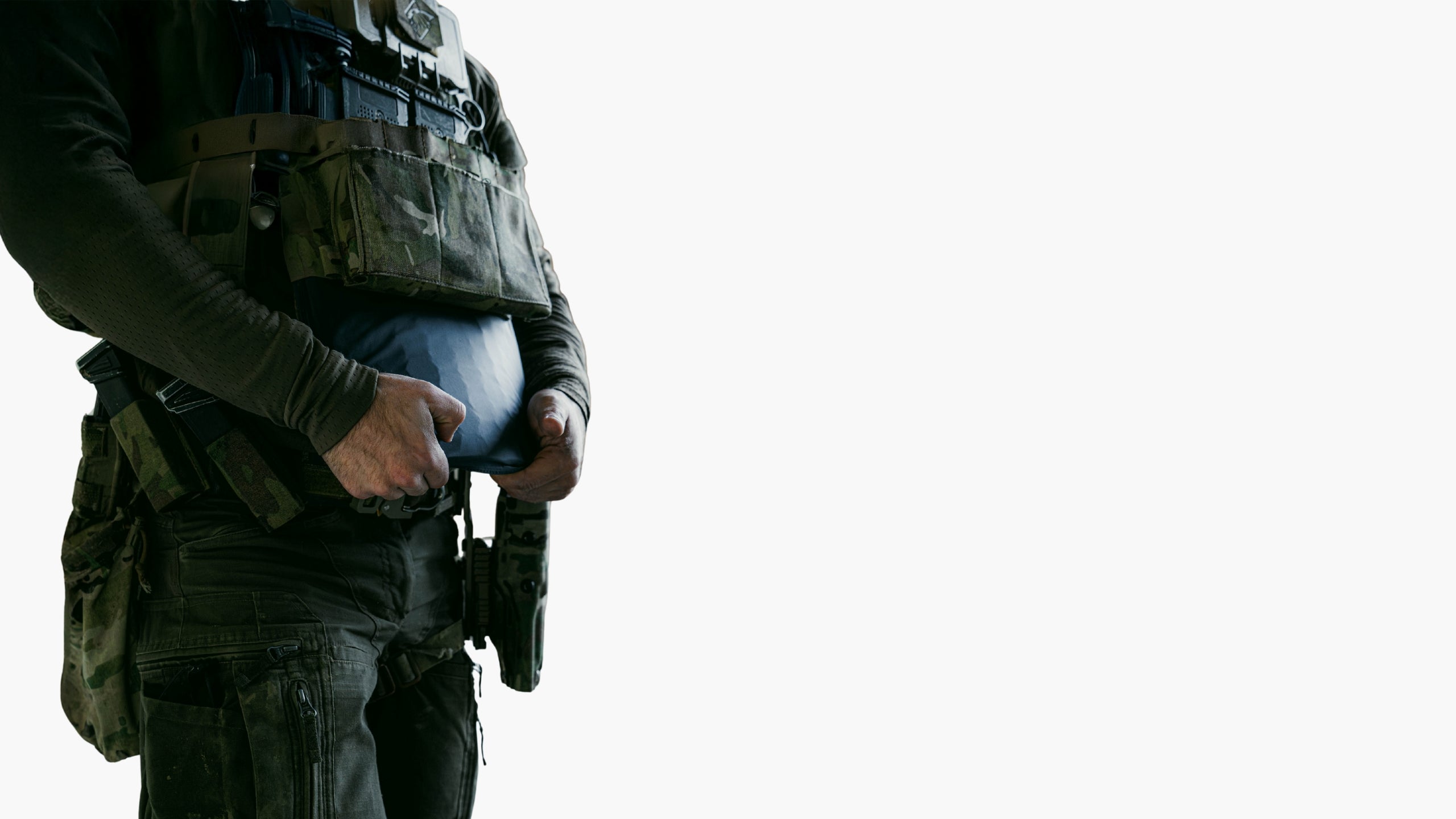 Operator inserting PGL Armor flexible ballistic plate into tactical vest