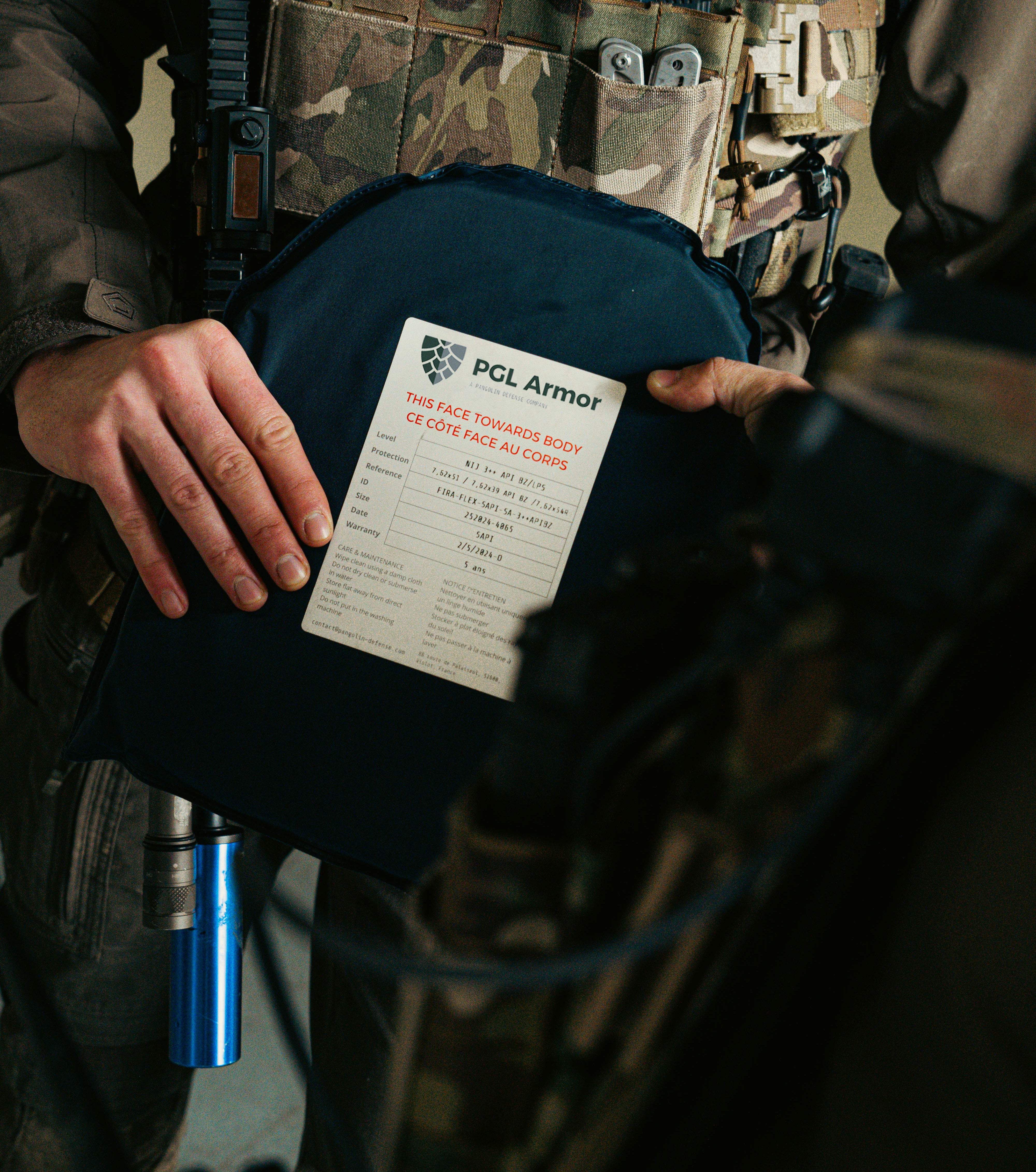 Operator holding a PGL Armor ballistic plate with NIJ certified label visible