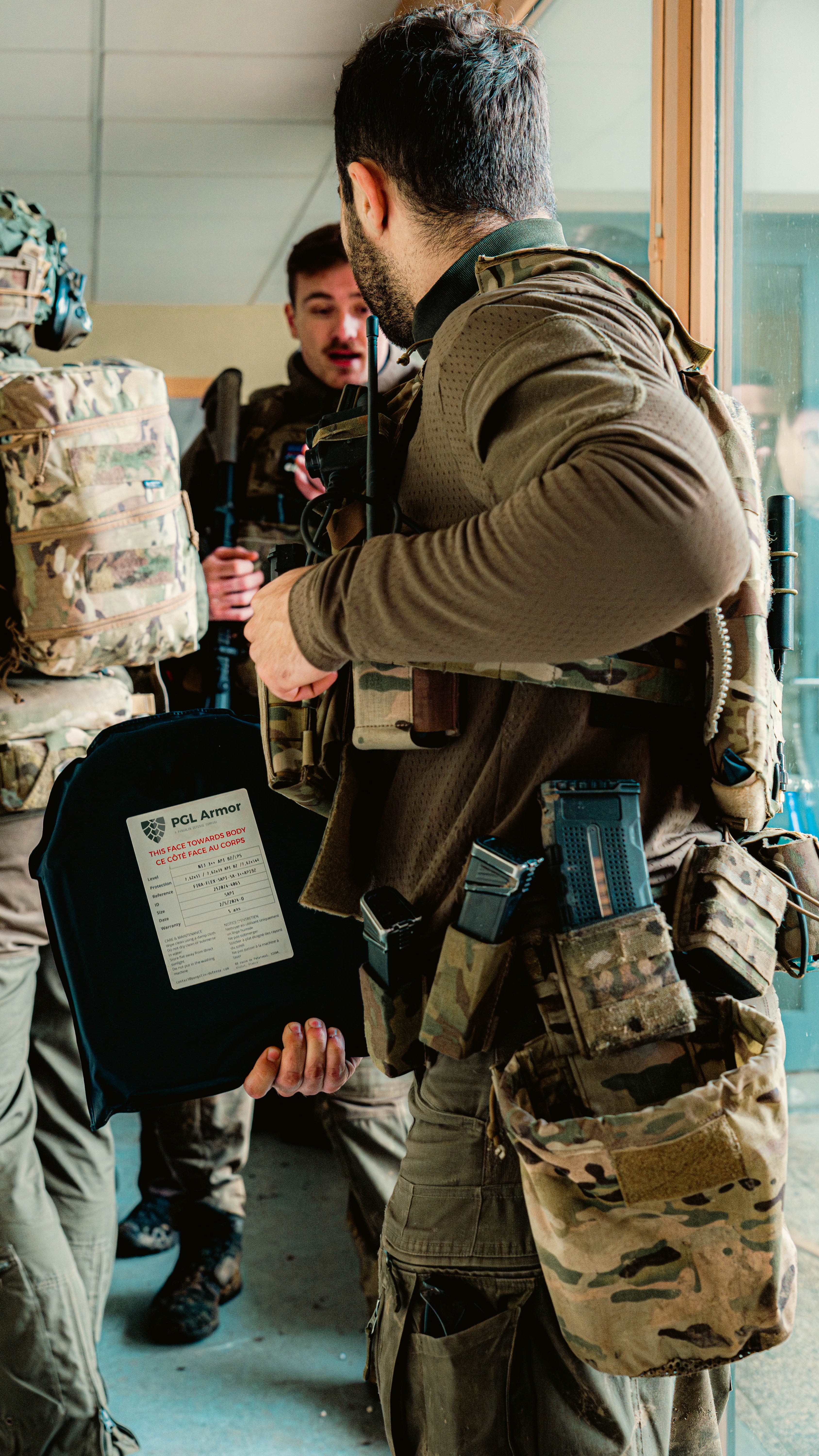 Operator holding a PGL Armor ballistic plate during tactical training session